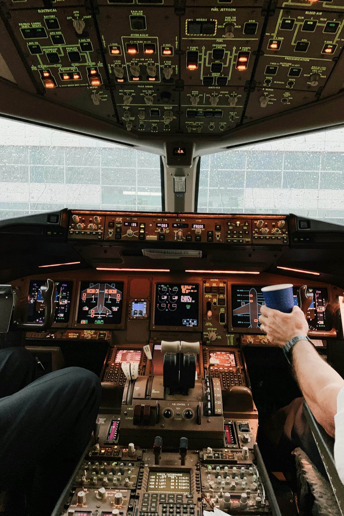 Interior view of a commercial airplane cockpit with pilots managing controls and instruments.